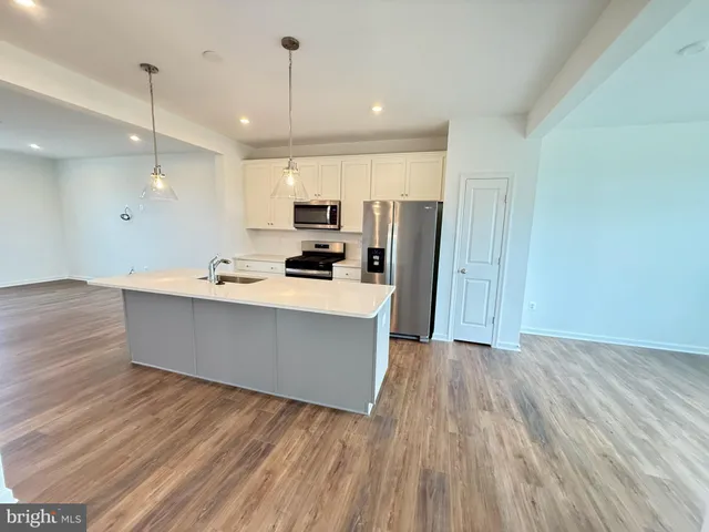 a kitchen with granite countertop a refrigerator and a stove top oven