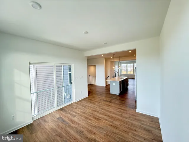 a view of wooden floor in an empty room with a window