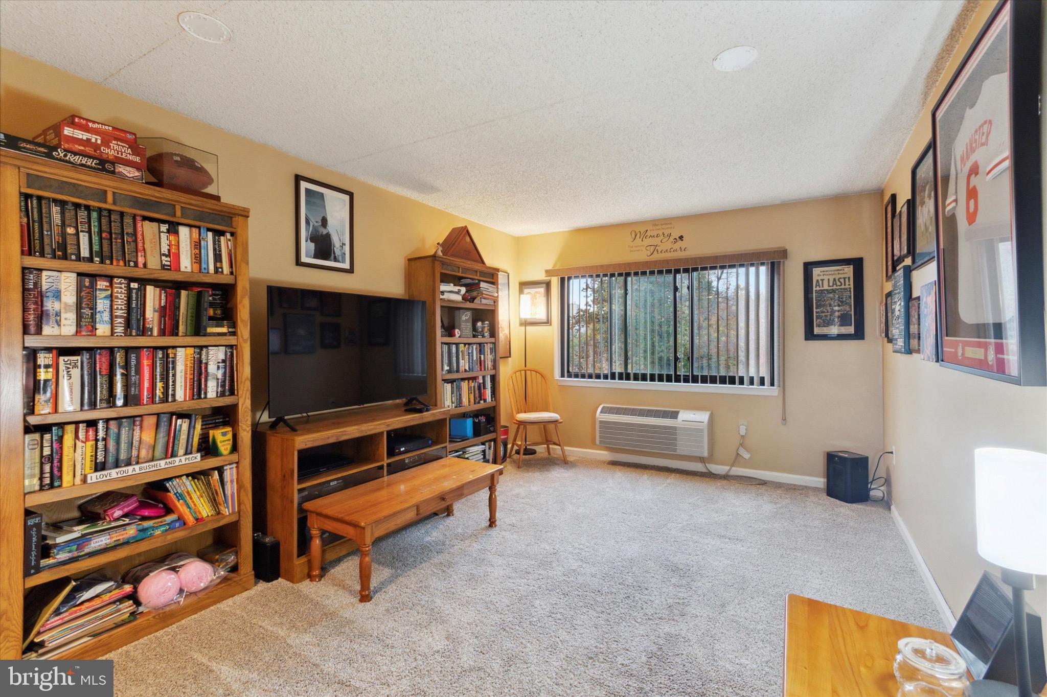 800 Avondale Road, Unit 5L Wallingford, PA 19086 - Photo 11 of 25 a living room with bookshelf and a flat screen tv