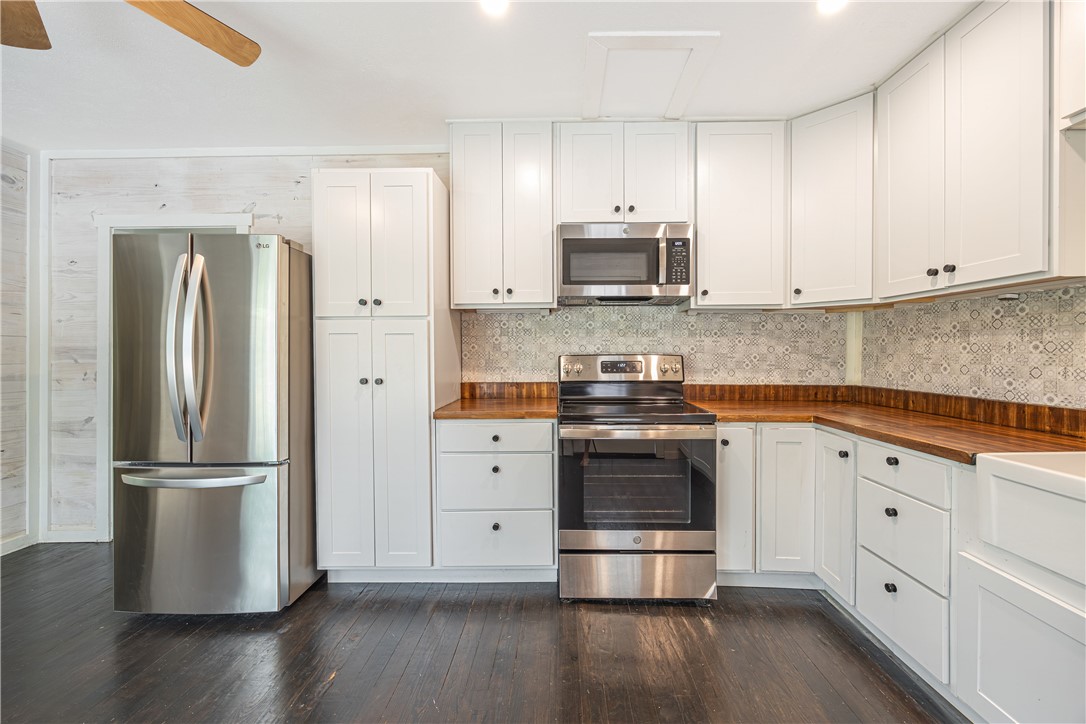 2283 Tigerpoint Road Brenham, TX 77833 - Photo 13 of 27 a kitchen with stainless steel appliances and white cabinets