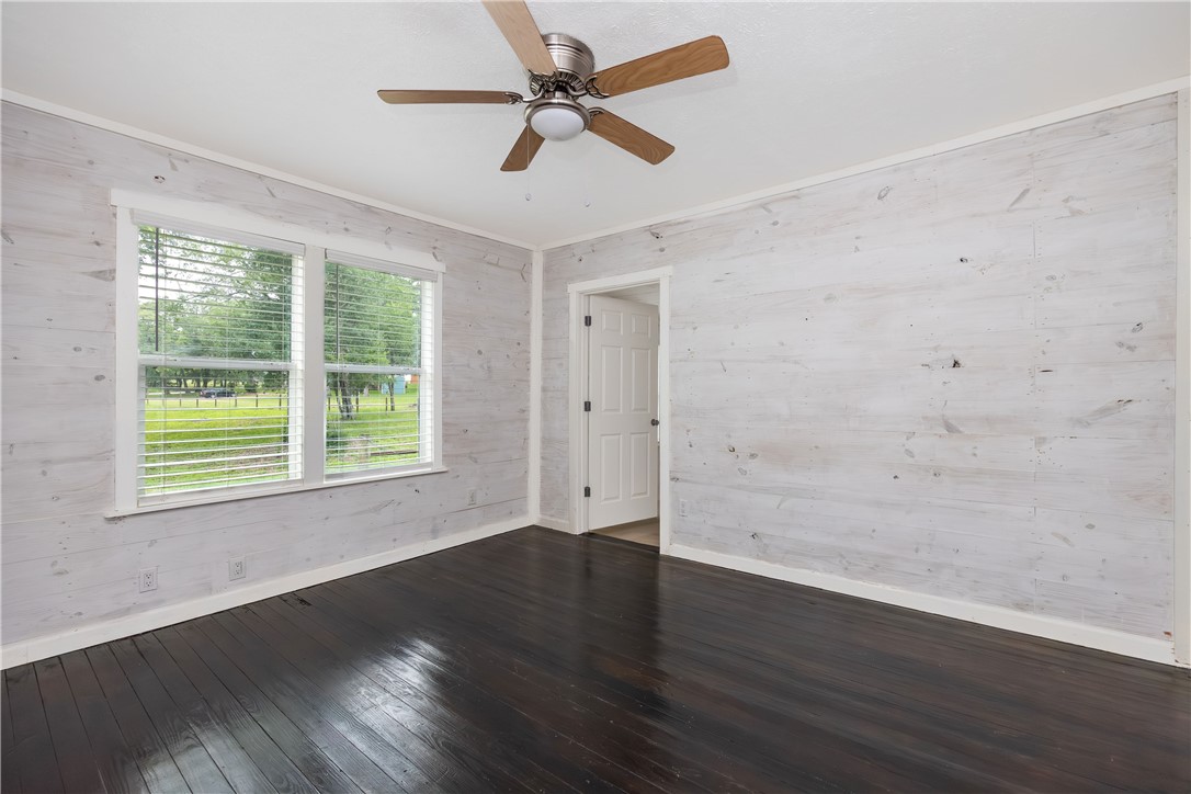 2283 Tigerpoint Road Brenham, TX 77833 - Photo 19 of 27 an empty room with wooden floor and windows