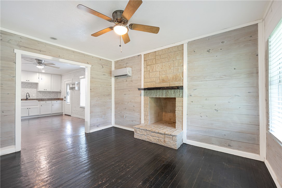 2283 Tigerpoint Road Brenham, TX 77833 - Photo 10 of 27 a view of a livingroom with wooden floor a ceiling fan and kitchen space