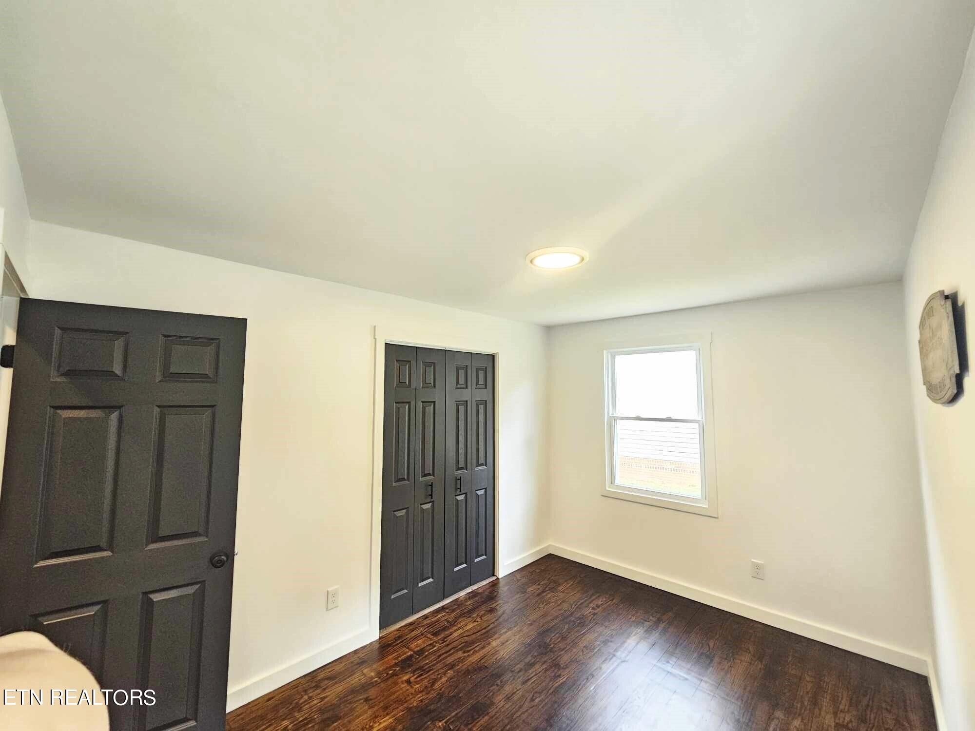 136 Main Road Maryville, TN 37804 - Photo 11 of 24 an empty room with wooden floor and windows