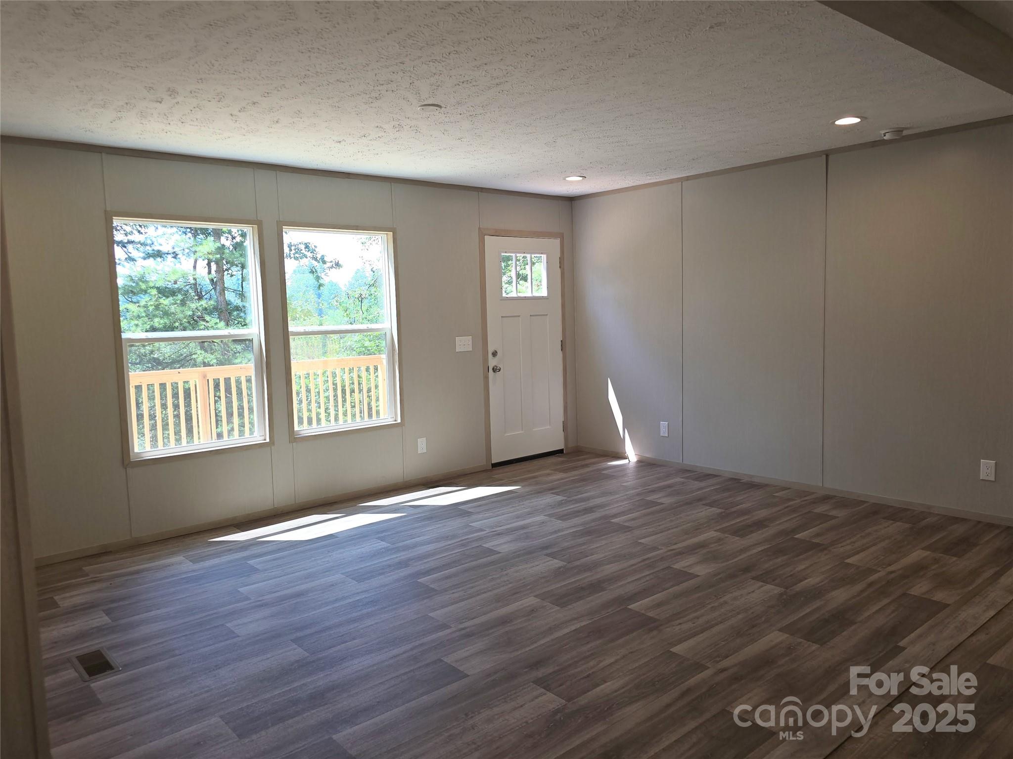 12 McGee Hl Road Fairview, NC 28730 - Photo 6 of 25 an empty room with wooden floor and windows