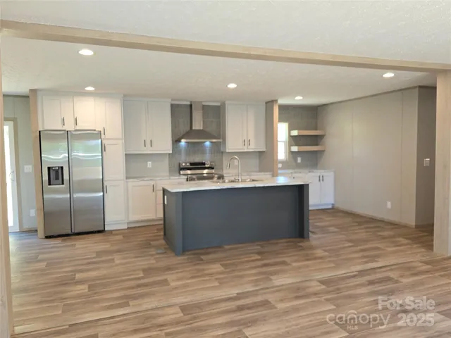 a kitchen with kitchen island stainless steel appliances a refrigerator sink and cabinets
