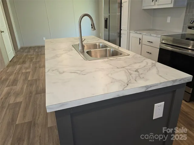 a close view of a sink a counter space and a stove in a kitchen