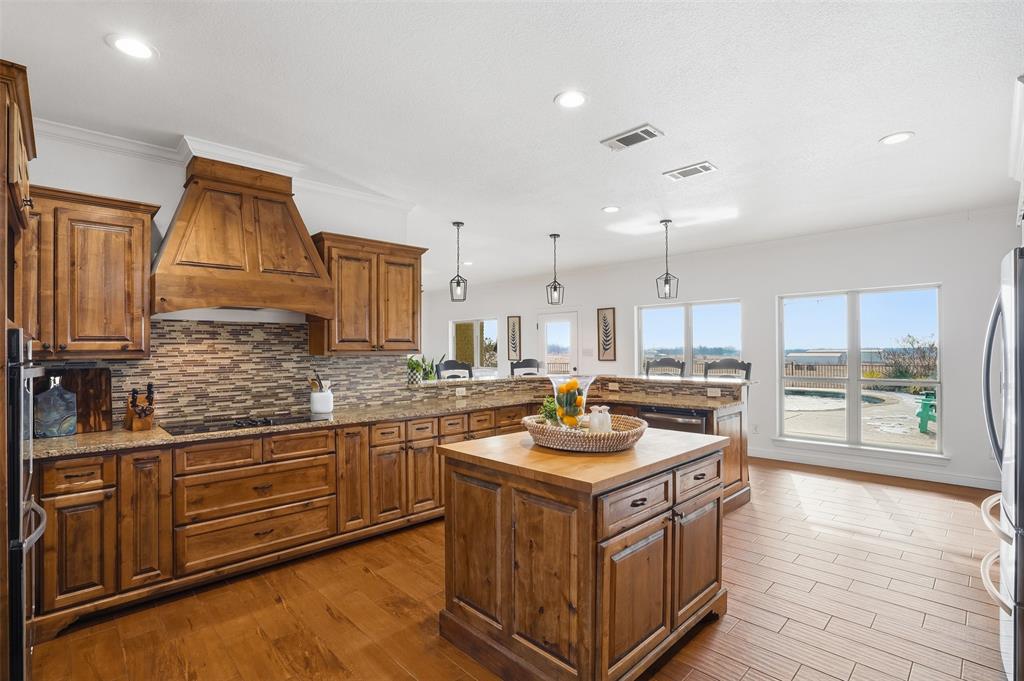 2701 County Road 1110 Rio Vista, TX 76093 - Photo 16 of 39 a kitchen that has a lot of cabinets in it and wooden floor