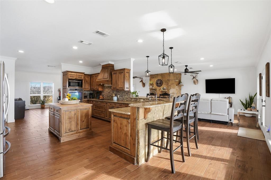 2701 County Road 1110 Rio Vista, TX 76093 - Photo 17 of 39 a kitchen with stainless steel appliances kitchen island granite countertop a table and chairs in it