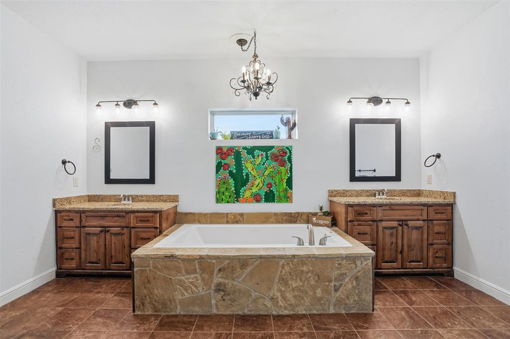 2701 County Road 1110 Rio Vista, TX 76093 - Photo 22 of 39 a spacious bathroom with a tub double vanity sink and mirror