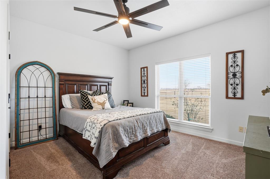 2701 County Road 1110 Rio Vista, TX 76093 - Photo 25 of 39 a bedroom with a bed a chandelier and a window
