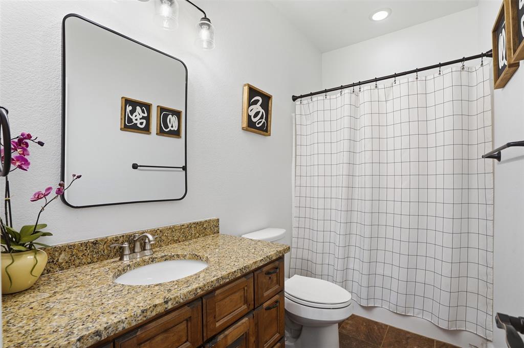 2701 County Road 1110 Rio Vista, TX 76093 - Photo 26 of 39 a bathroom with a granite countertop toilet sink and mirror