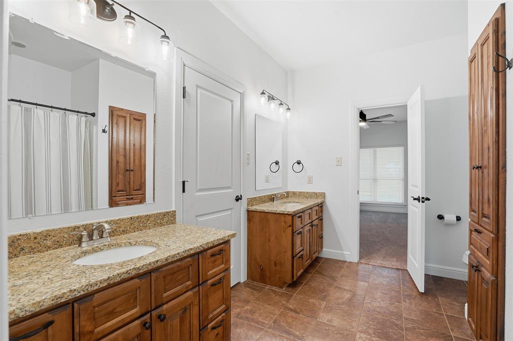 2701 County Road 1110 Rio Vista, TX 76093 - Photo 29 of 39 a spacious bathroom with a granite countertop sink and a mirror