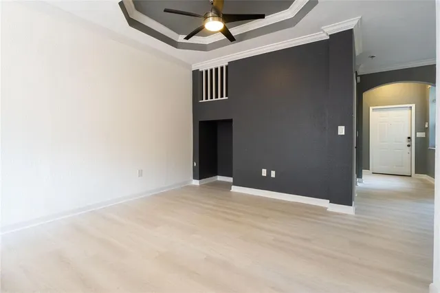 a view of an empty room with a chandelier fan