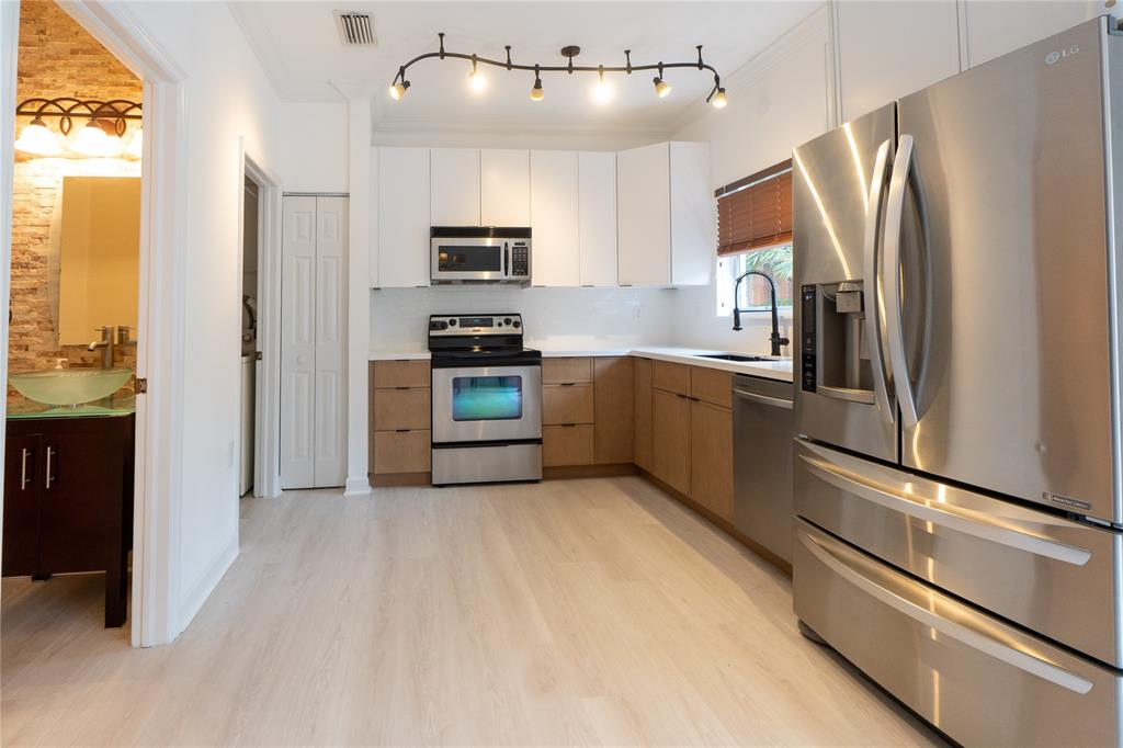 13519 Southwest 50th Court Miramar, FL 33027 - Photo 9 of 26 a kitchen with stainless steel appliances granite countertop a refrigerator a stove a sink and a microwave