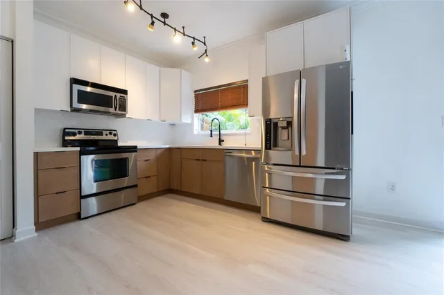 a kitchen with stainless steel appliances a refrigerator sink and microwave