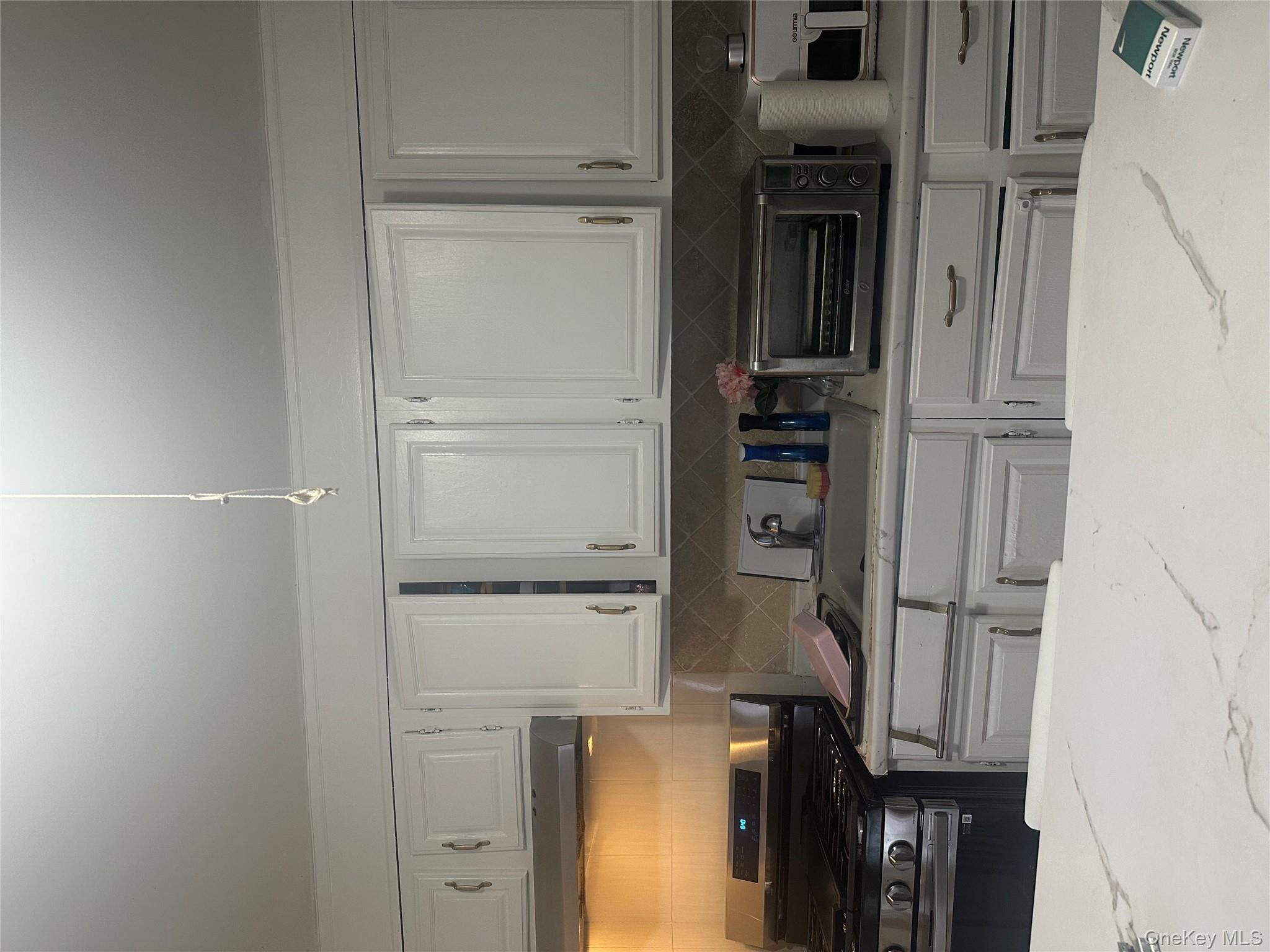 21 Drake Avenue New Rochelle, NY 10805 - Photo 13 of 18 a kitchen with white cabinets and appliances