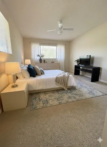 a large bedroom with a bed furniture and a flat screen tv