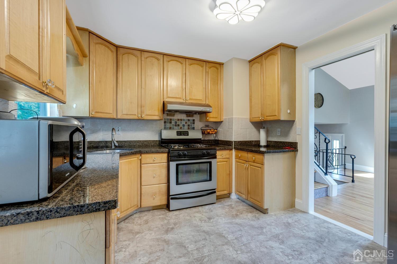 7 Colburn Road East Brunswick, NJ 08816 - Photo 13 of 25 a kitchen with a sink a stove and cabinets