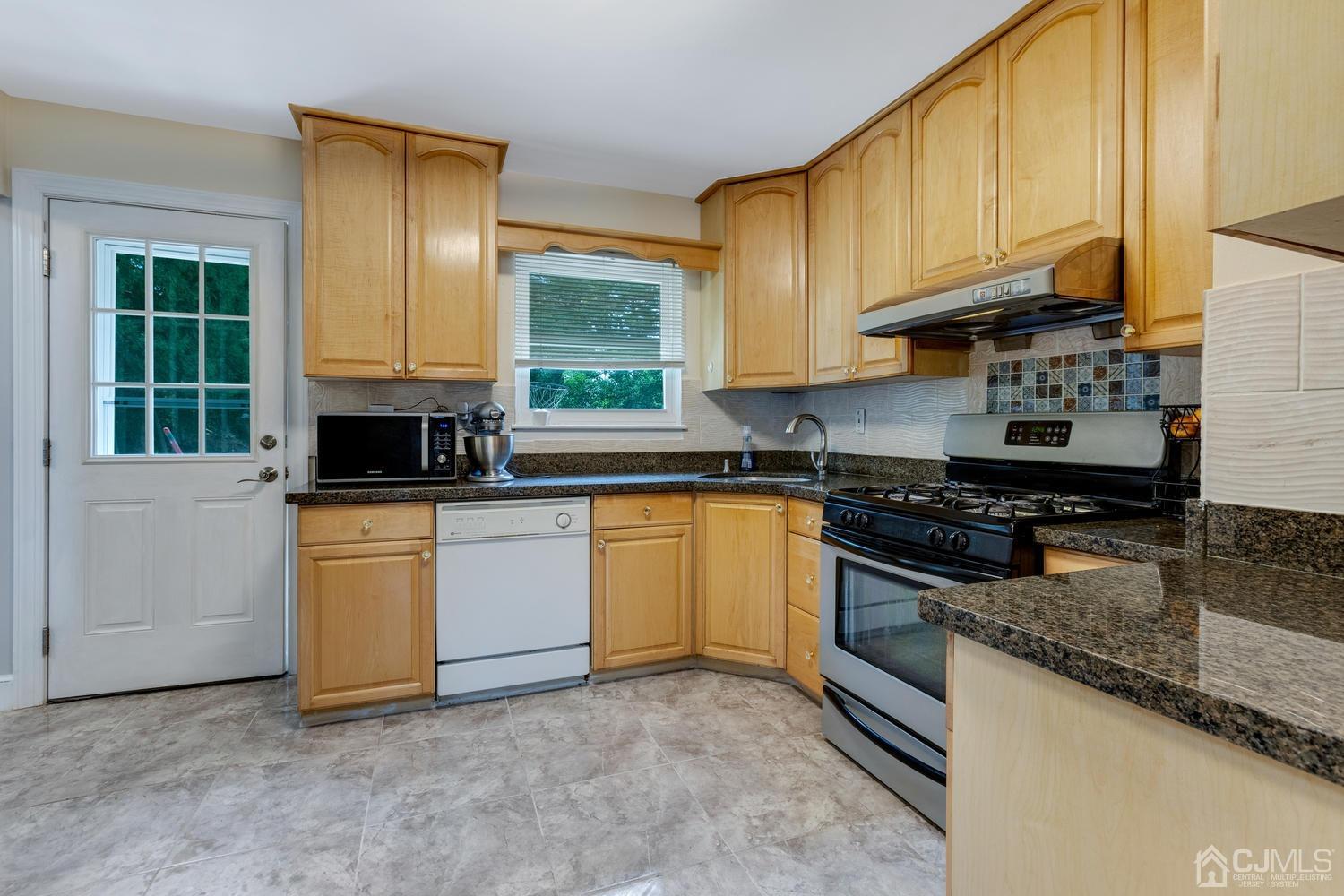 7 Colburn Road East Brunswick, NJ 08816 - Photo 14 of 25 a kitchen with stainless steel appliances granite countertop a stove a sink and a microwave