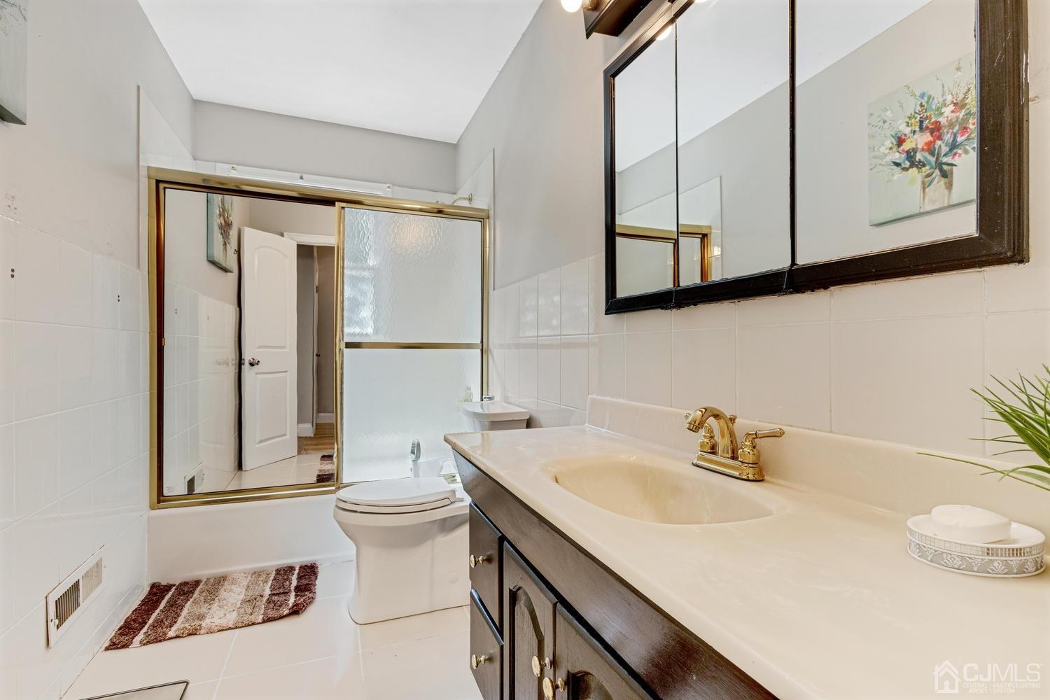 7 Colburn Road East Brunswick, NJ 08816 - Photo 20 of 25 a bathroom with a sink a toilet and mirror