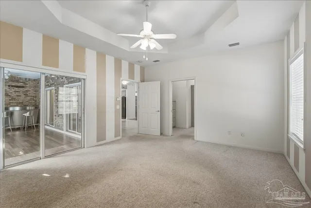 a view of a room with a ceiling fan and window