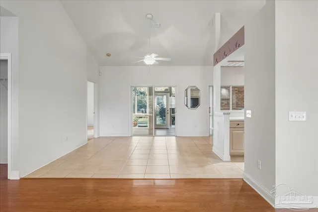 a view of a hallway with wooden floor and a living room
