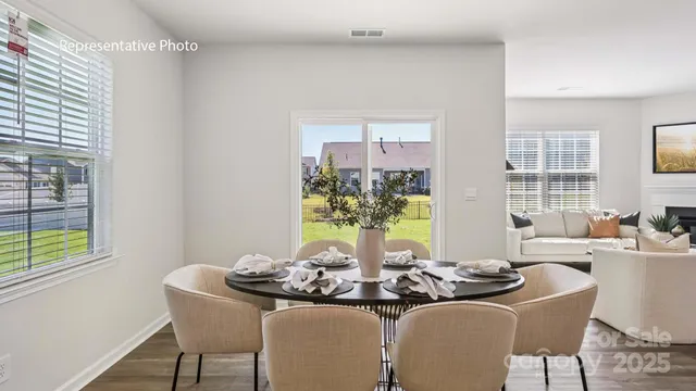 a dining room with furniture and a potted plant