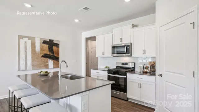a kitchen with stainless steel appliances granite countertop a sink a stove and a refrigerator