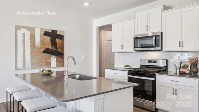 a kitchen with stainless steel appliances granite countertop a sink a stove and microwave