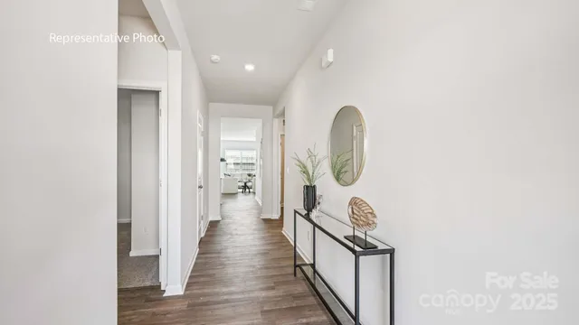 a view of a hallway with wooden floor and entryway