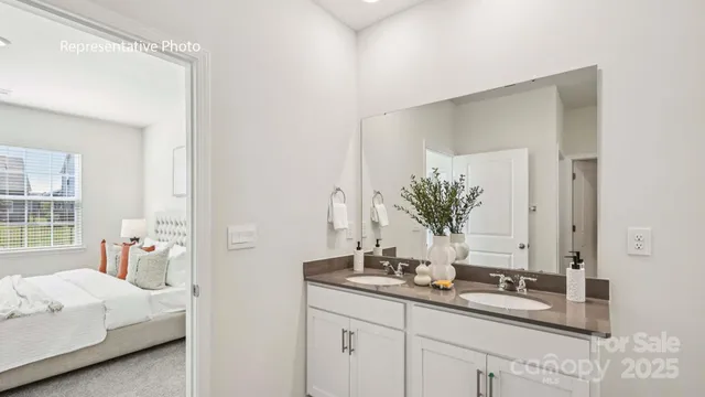 a bath room with a double vanity sink and a mirror