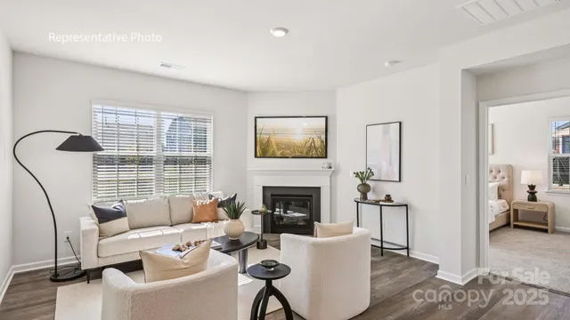 a living room with furniture a fireplace and a large window