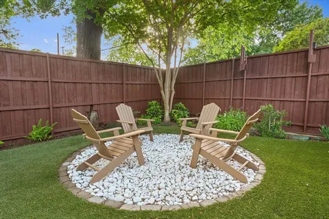 a view of a backyard with chairs potted plants and a wooden fence