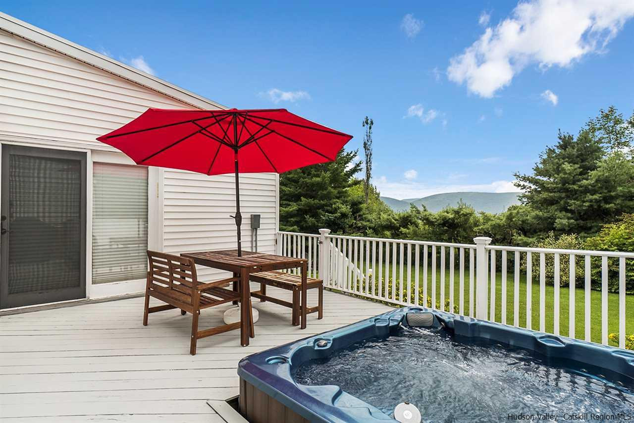 5999 Route 23c Route Prattsville, NY 12468 - Photo 2 of 31 a view of a roof deck with table and chairs under an umbrella