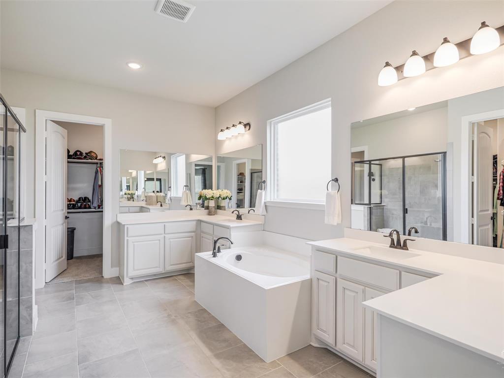 544 Majors Road Van Alstyne, TX 75495 - Photo 16 of 36 a large white bathroom with a double vanity sink a mirror and a bathtub