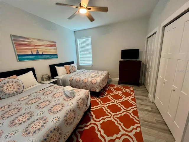 a bedroom with two large bed and a window