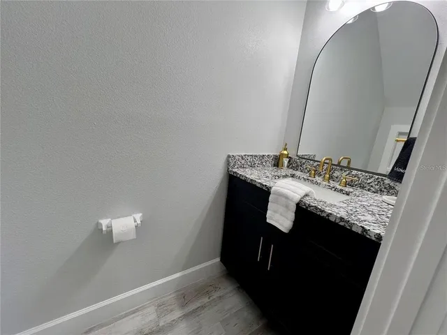 a bathroom with a granite countertop sink and a mirror