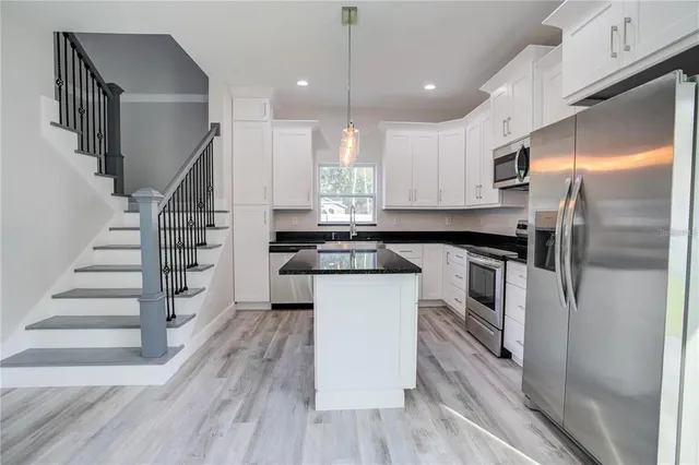 a kitchen with white cabinets and stainless steel appliances