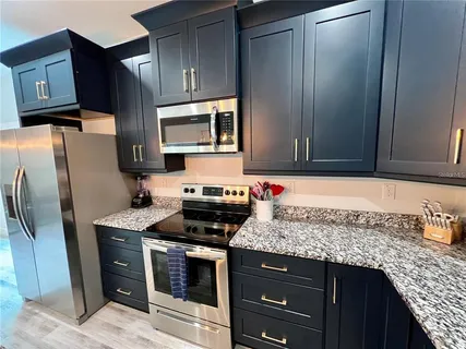 a kitchen with stainless steel appliances granite countertop a refrigerator stove and microwave
