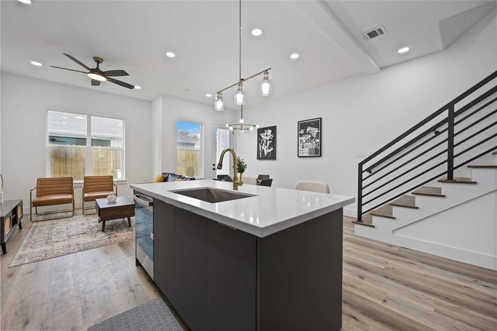 1805 Emir Street, Unit L Houston, TX 77009 - Photo 3 of 35 The island is open to the living and dining areas and features sleek light fixtures and quartz countertops. Gorgeous floors adorn the living space.