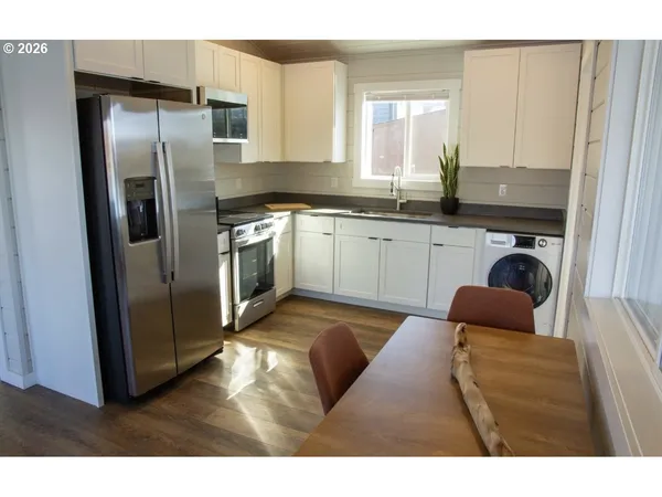 a kitchen with stainless steel appliances granite countertop a refrigerator a sink a stove and island