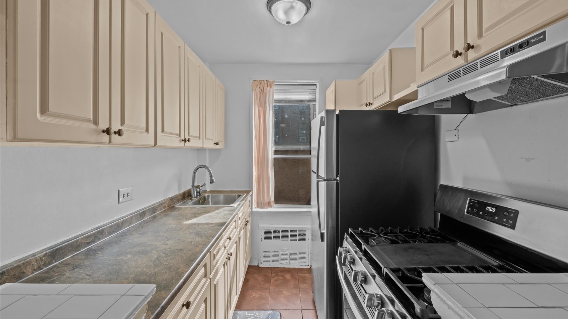 3520 Tryon Avenue, Unit 502 Bronx, NY 10467 - Photo 5 of 13 a kitchen with granite countertop a stove and a refrigerator