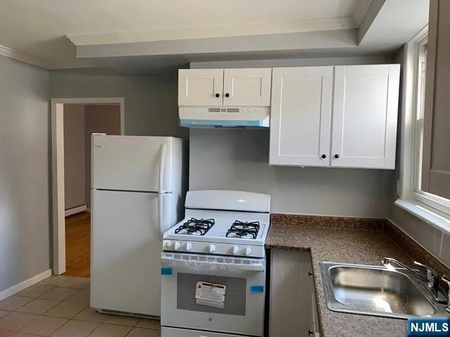 a stove top oven sitting inside of a kitchen