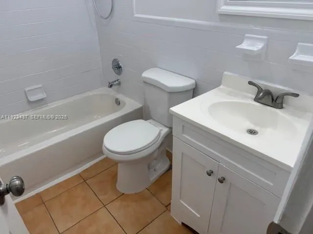 a white toilet sitting next to a bath tub