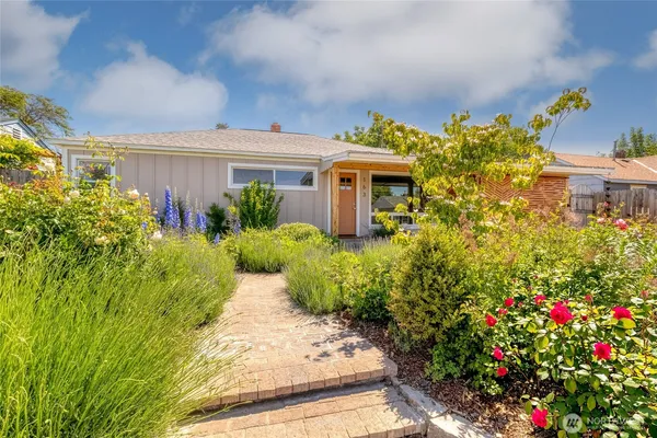 a flower garden is sitting in front of house