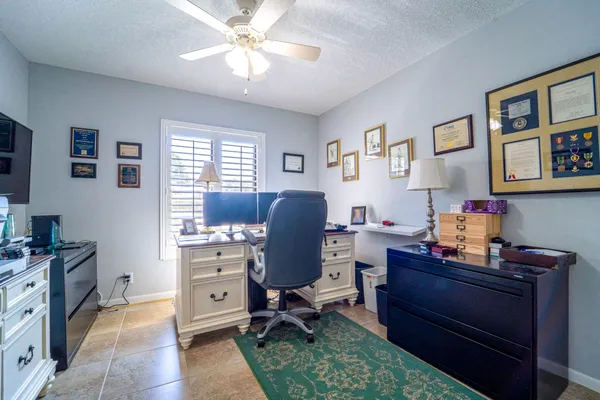 a view of a workspace with furniture and a window