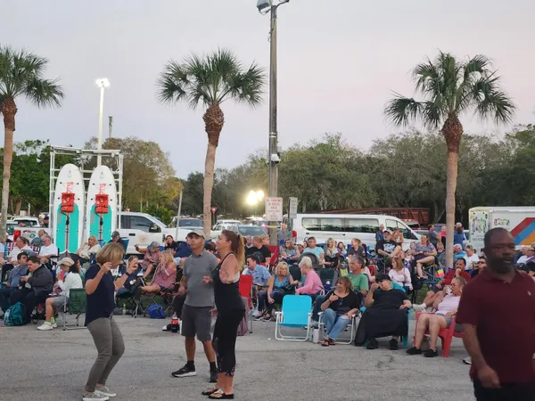 a group of people standing around a park