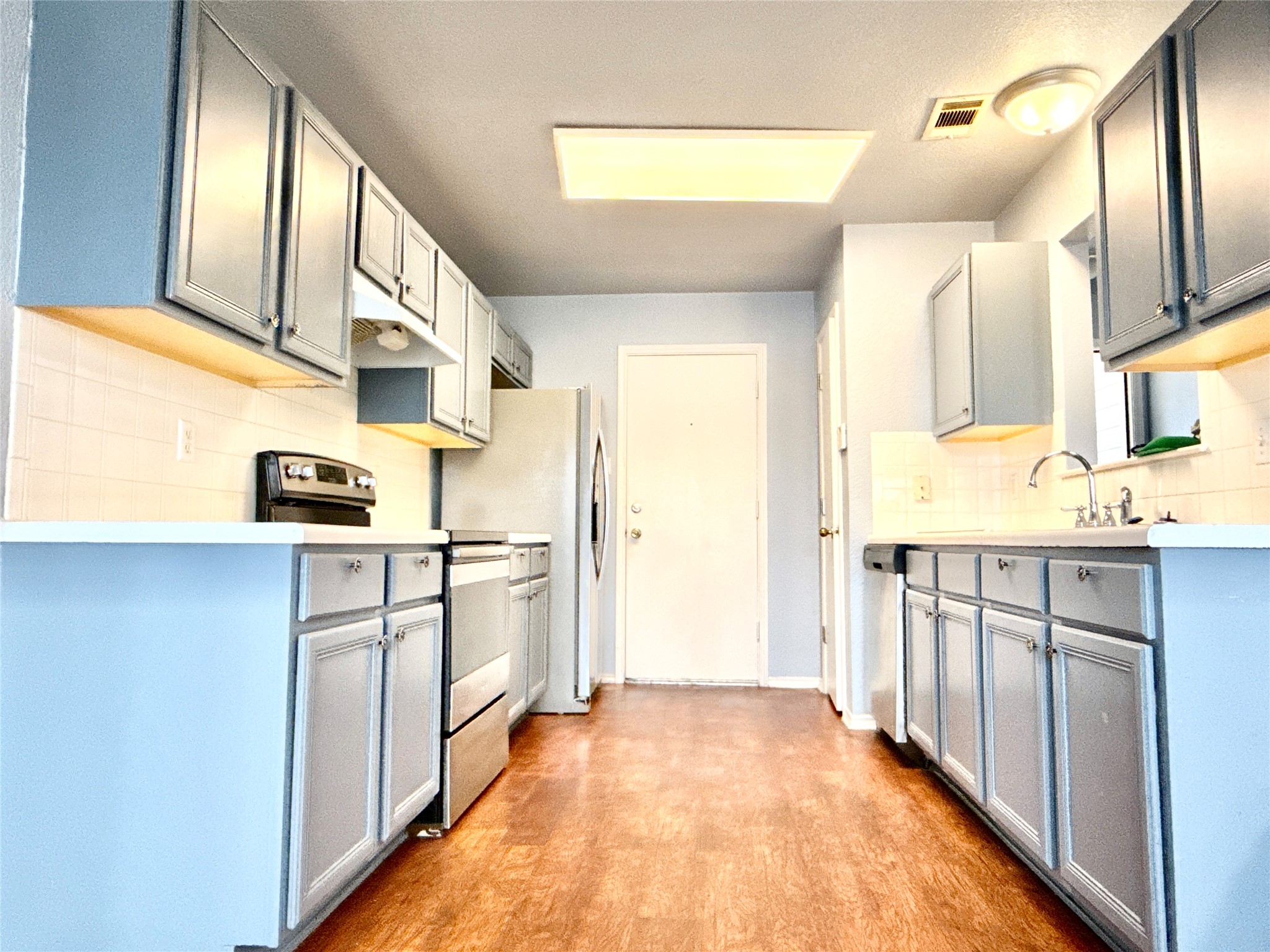 2703 Little Nolan Road Killeen, TX 76542 - Photo 11 of 11 Kitchen featuring stainless steel appliances, gray cabinets, decorative backsplash, light countertops, and light wood-style floors
