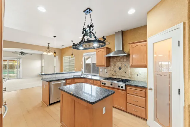 a kitchen with stainless steel appliances granite countertop a sink a stove and a refrigerator