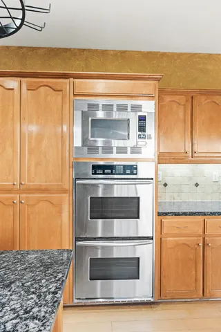 a kitchen with granite countertop cabinets and steel stainless steel appliances
